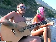 He plays guitar for her and fucks her on the beach