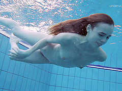Skinny brunette bint enjoys showing off her twat in the pool