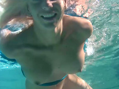 Blonde with natural tits displaying pussy while swimming