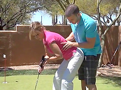 Husband teaches his wife how to golf