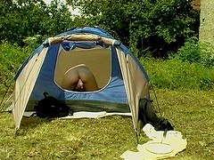 Camping girl is all alone in her tent and playing with a toy