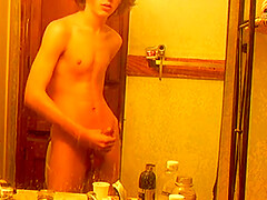 A hot skinny boy with curly hair films himself jerking off in the bathroom mirror.